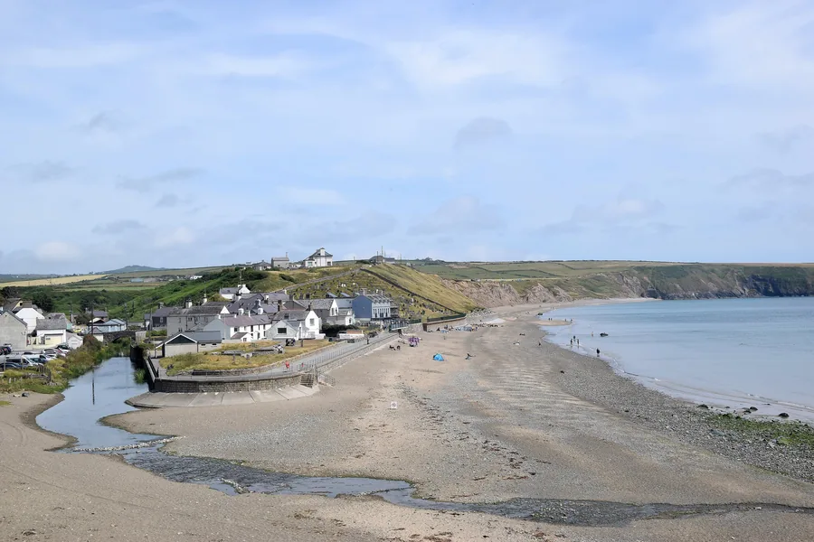 Aberdaron's houses above the sand where the Afon Daron crosses the beach, the bay opening south beyond them, Llŷn Peninsula, Gwynedd.
