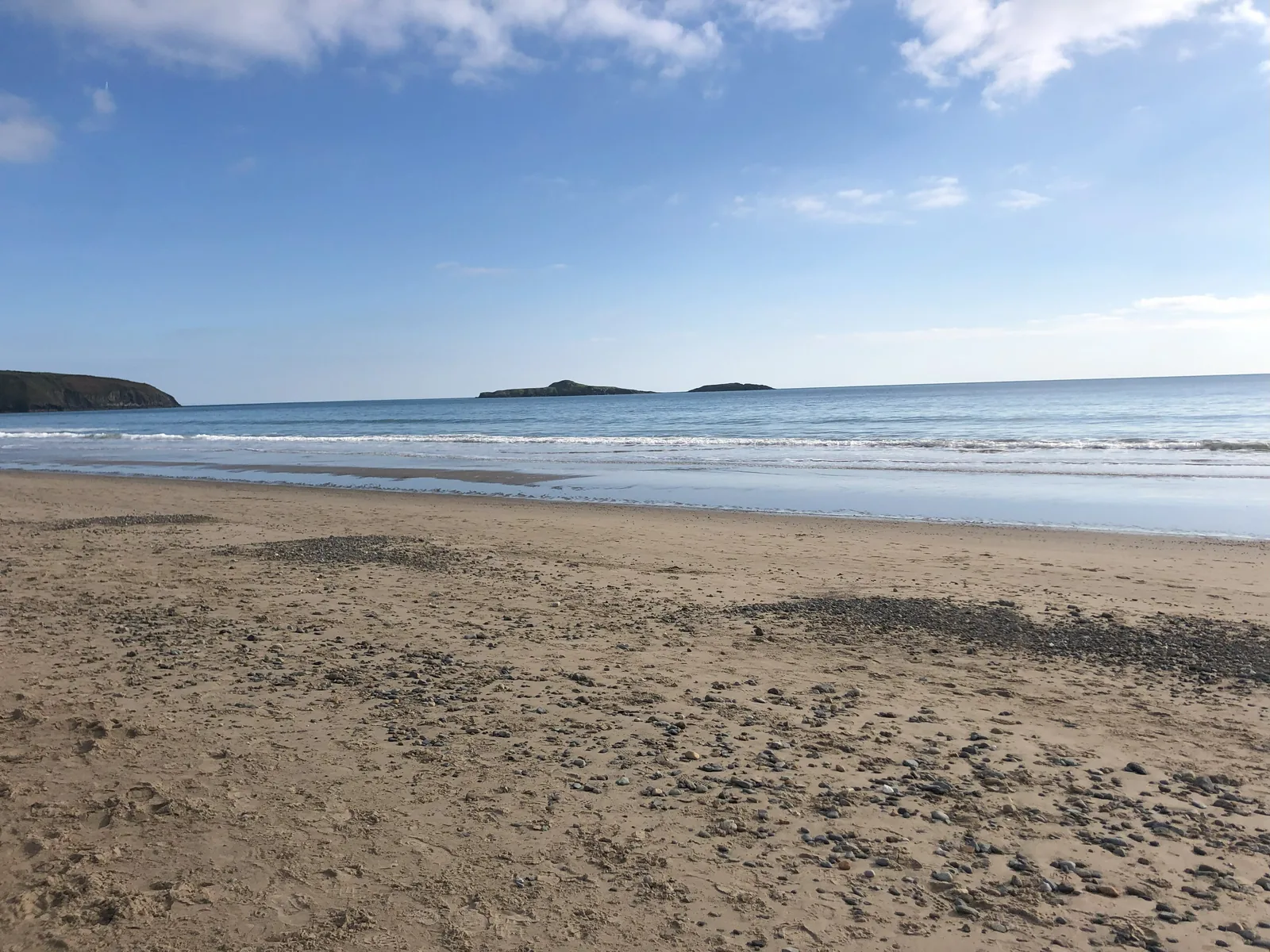 The open sand of Traeth Aberdaron at low water, with the islands of Ynysoedd y Gwylanod low on the horizon
