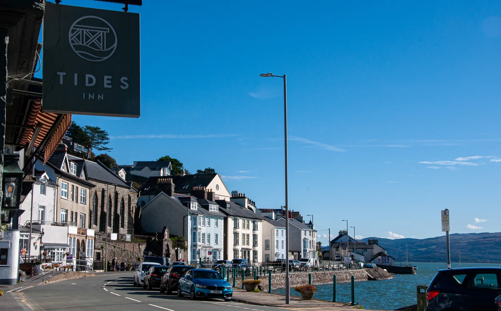 The seafront at Aberdyfi looking east, painted terraces on one side and the estuary wall on the other