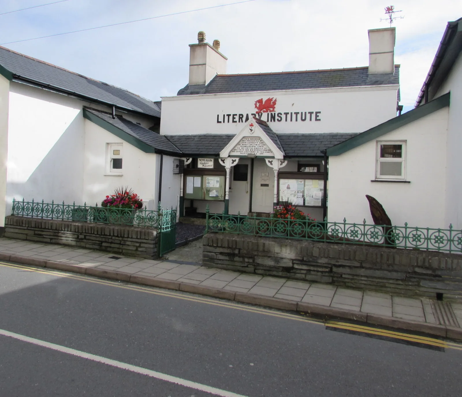 The white front of the Aberdovey Literary Institute, its name painted across the gable beneath a Welsh dragon