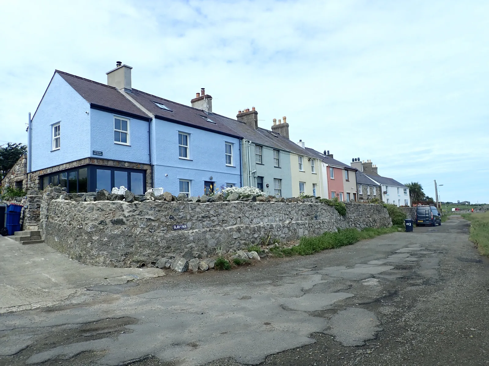 A terrace of colour-washed houses at Aberffraw standing above the estuary