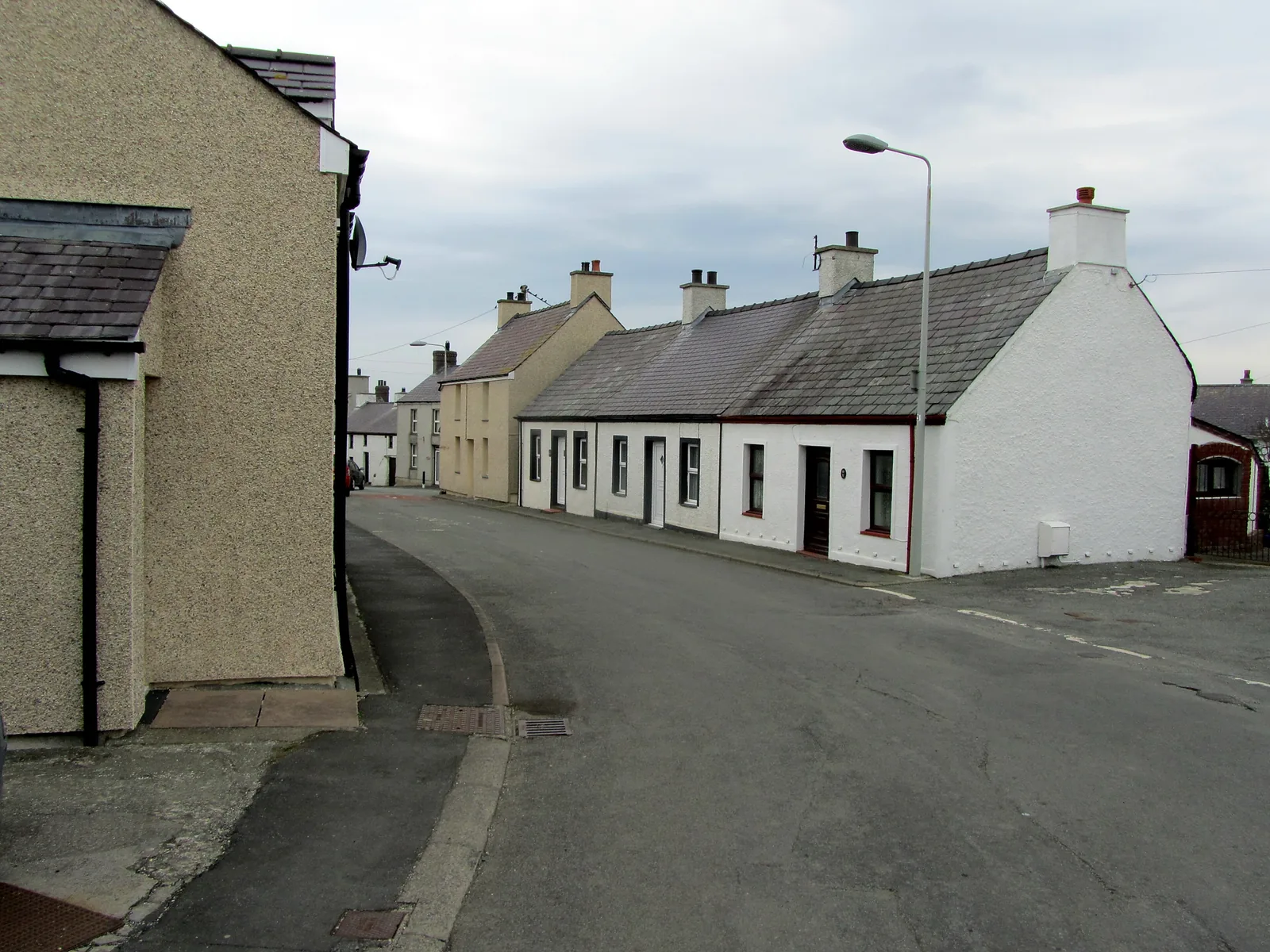 Whitewashed houses lining the road at the entrance to Aberffraw village