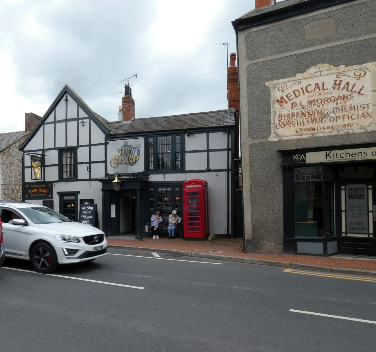 Timber-framed and painted Victorian frontages along Market Street, Abergele, with a red telephone box on the pavement