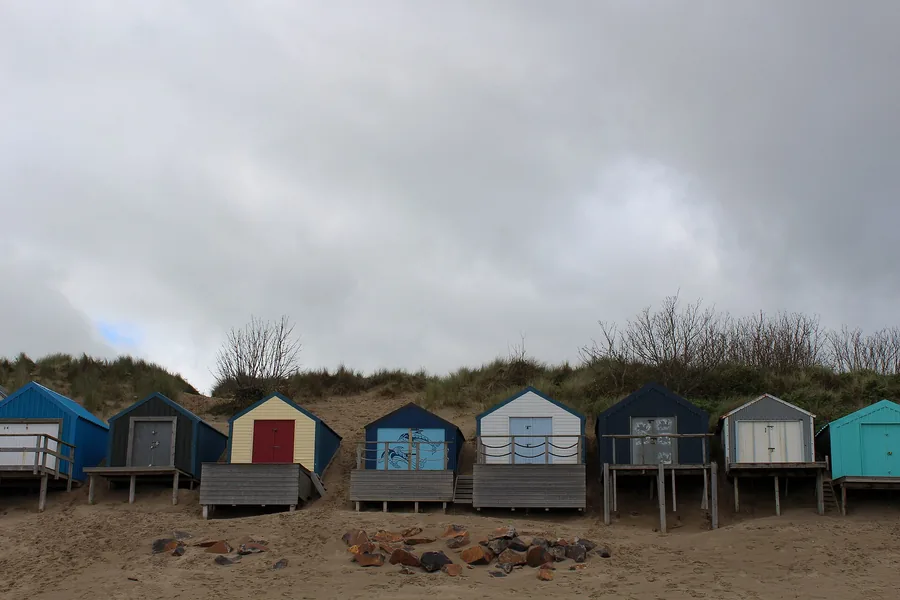 Colourful beach huts on the headland above Porth Fawr beach, Abersoch, Llŷn Peninsula.