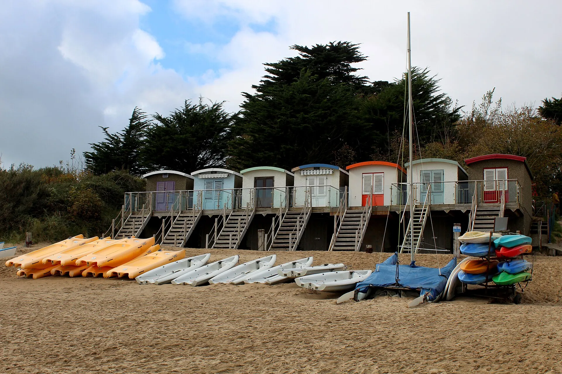 Rows of painted beach huts on the headland above the sand at Abersoch, the Llŷn Peninsula