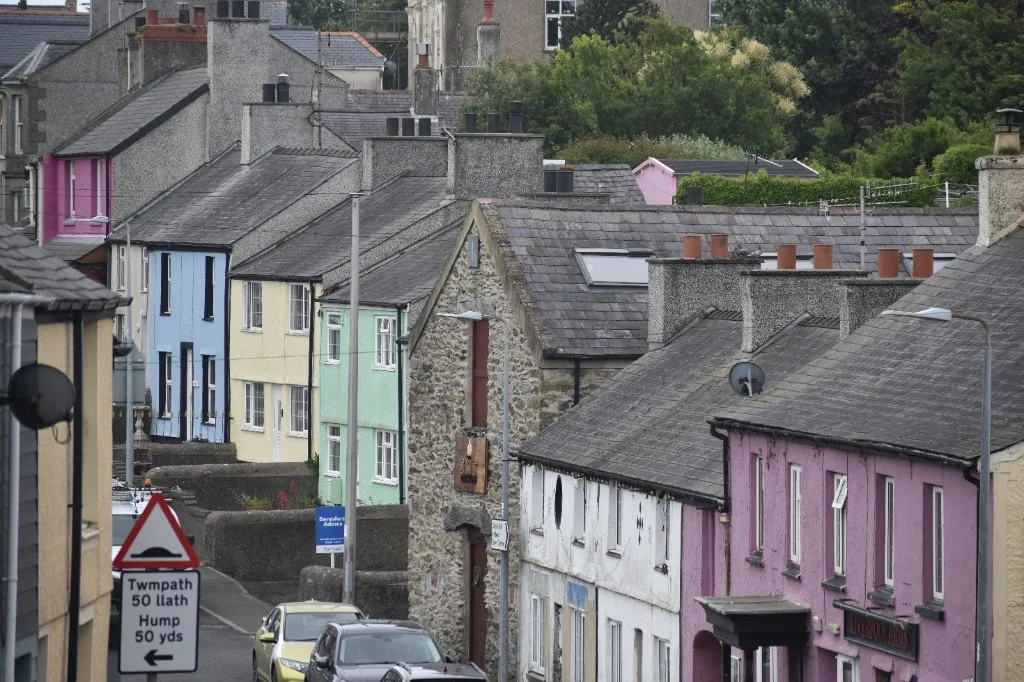 Pastel-painted terraces and slate roofs stepping down Machine Street at Amlwch Port