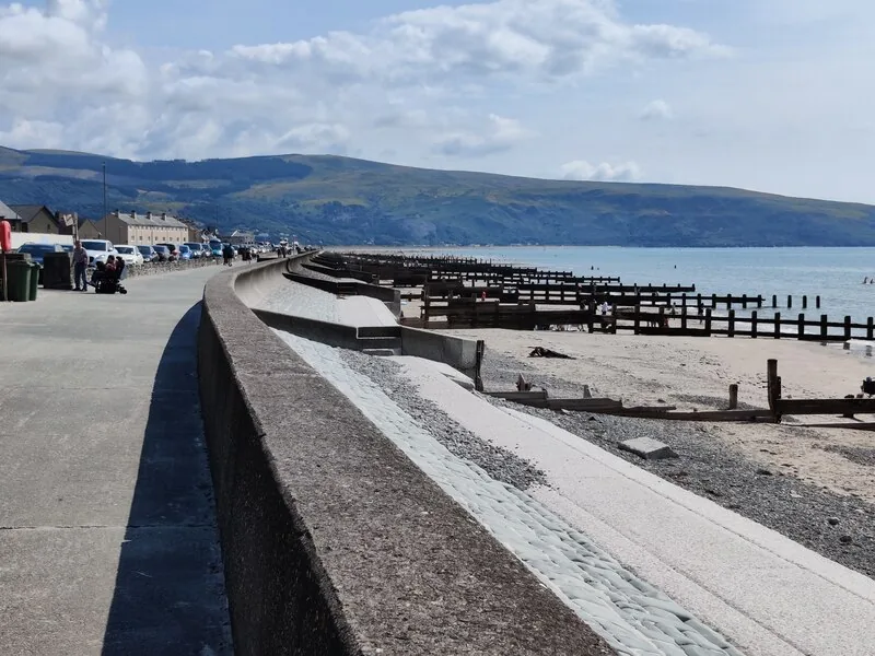 The promenade and beach at Barmouth, with the hills above Fairbourne across the bay
