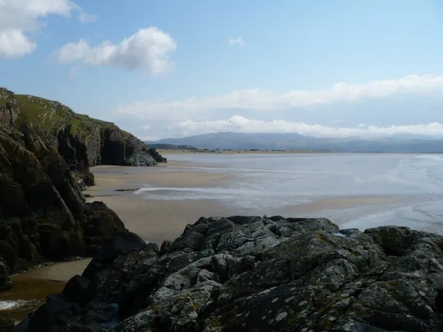 The rocky headland at Black Rock Sands, seen across the sand at low tide.