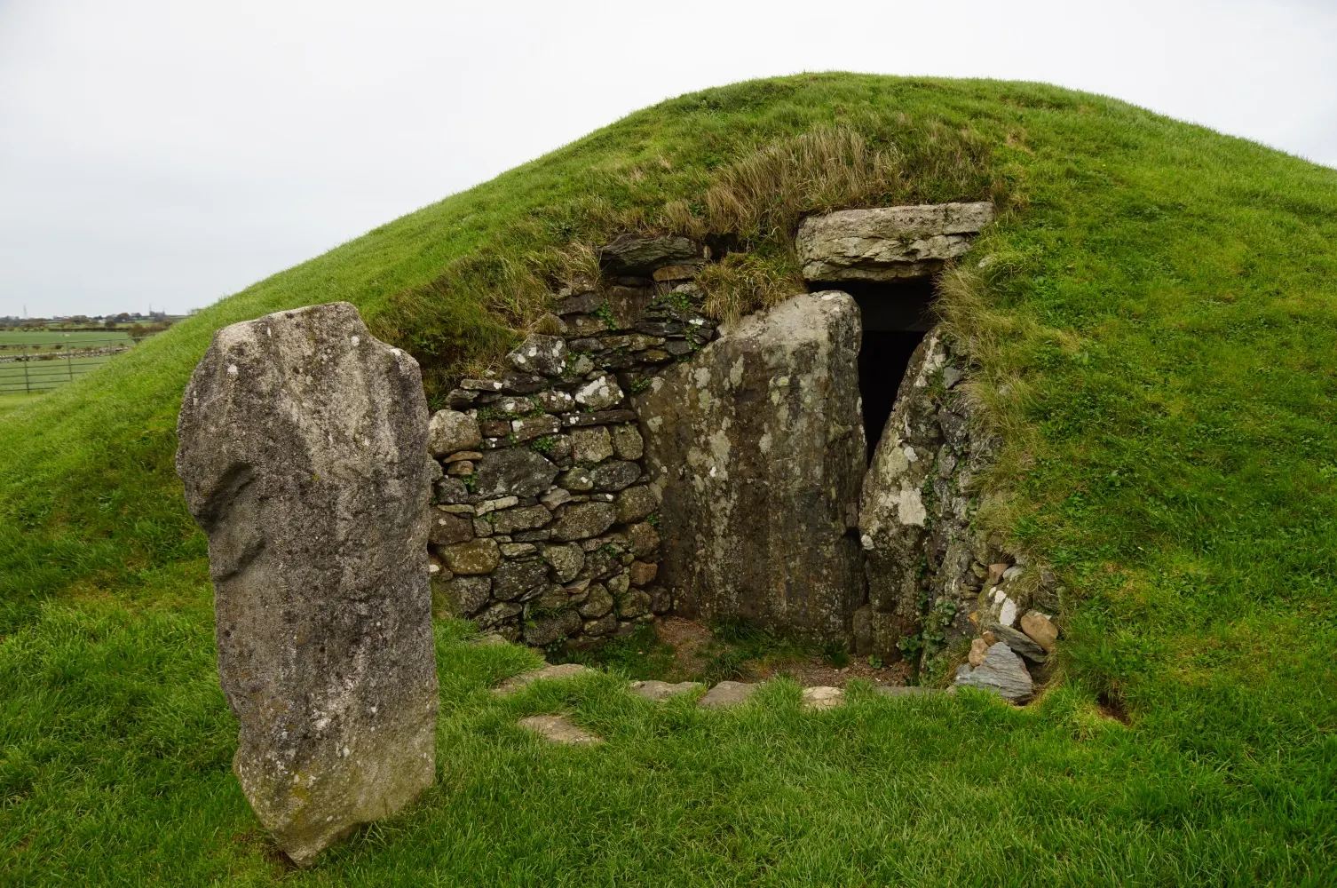 A replica of the carved pattern stone standing on the west side of the Bryn Celli Ddu mound.