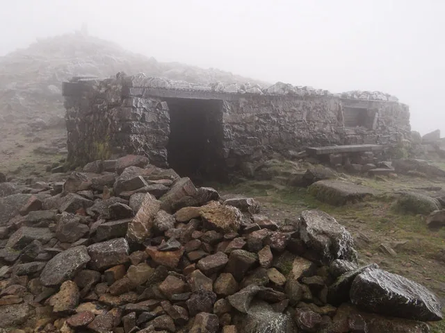 A steep, loose path falling away down the flank of Cadair Idris under a grey sky