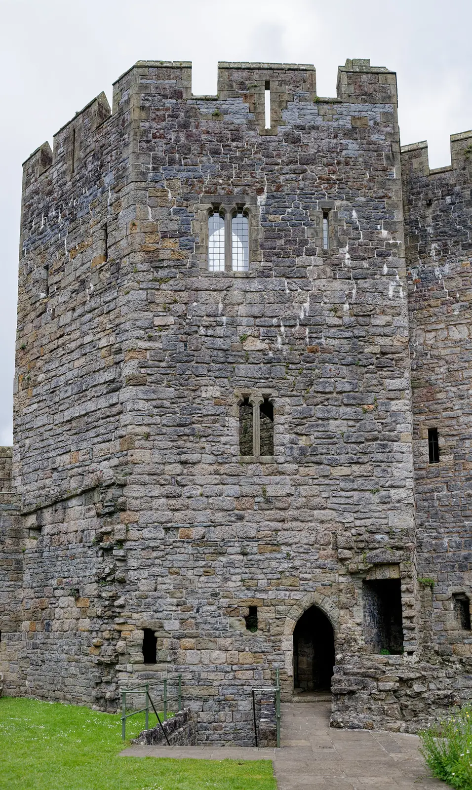 The Well Tower at Caernarfon Castle, a tall square tower with mullioned windows and an arched doorway.