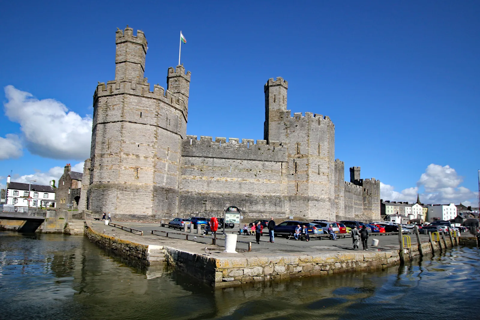 Caernarfon Castle seen from the west across the water, its banded towers above the quay
