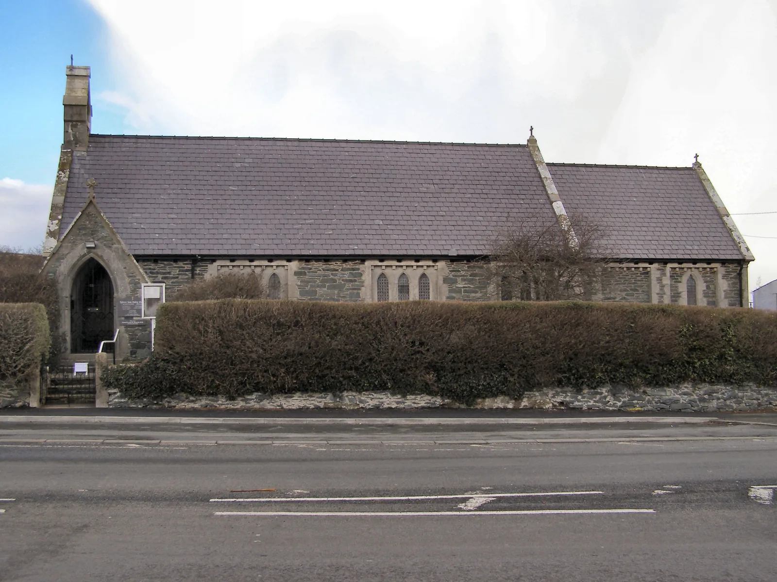 St Padrig's Church, Cemaes, a stone Victorian church seen in full elevation from the road