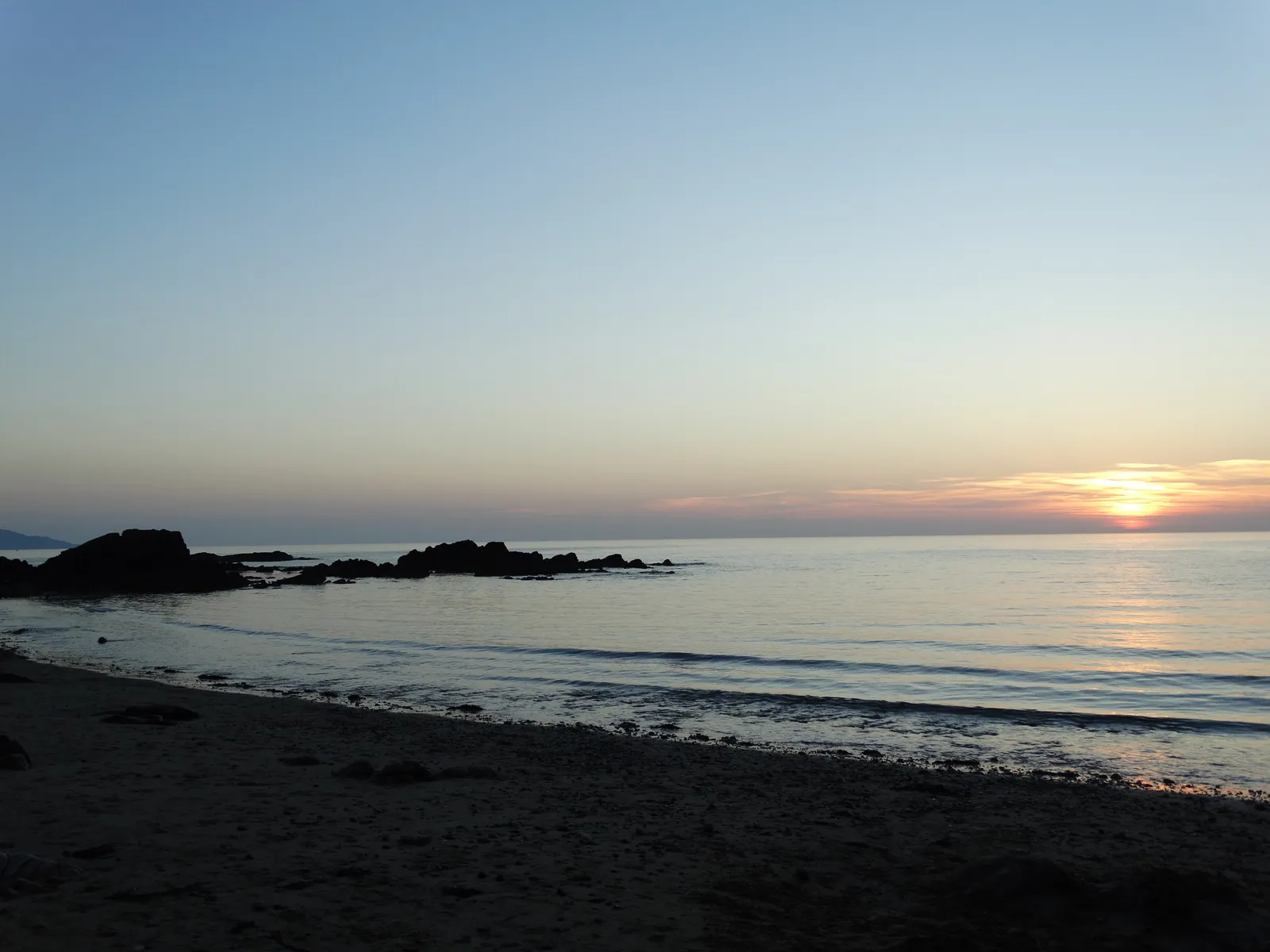 Church Bay at sundown: the Irish Sea catching light at the end of the day, Anglesey coast path cliffs in silhouette.
