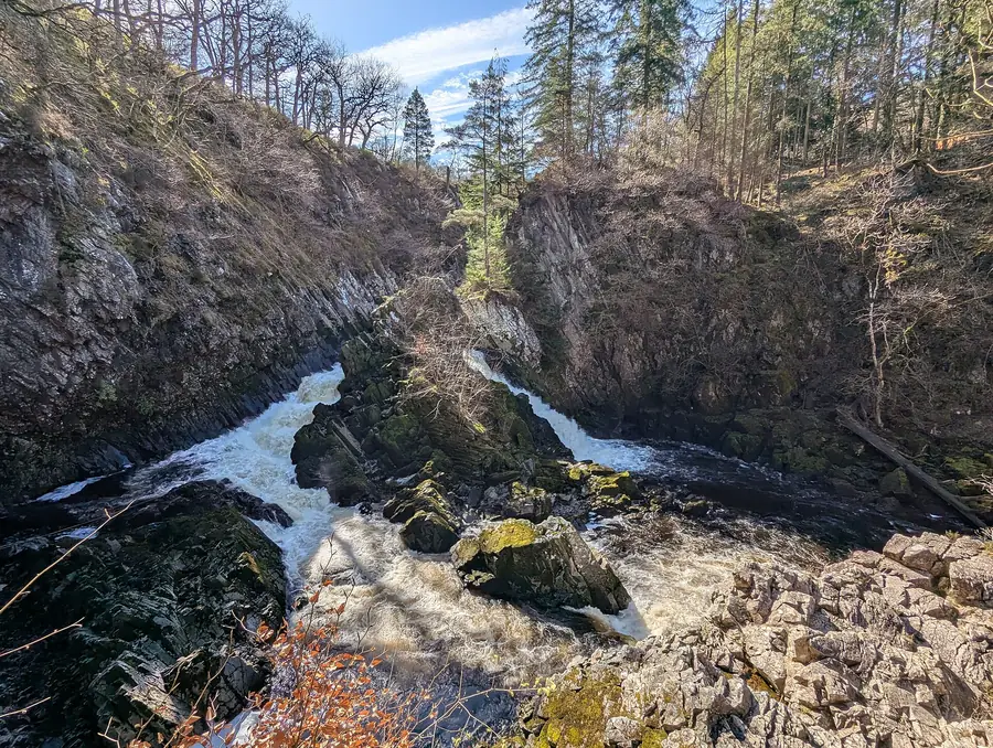 White water rushing through the wooded rock gorge of Conwy Falls on the River Conwy near Betws-y-Coed, Conwy.