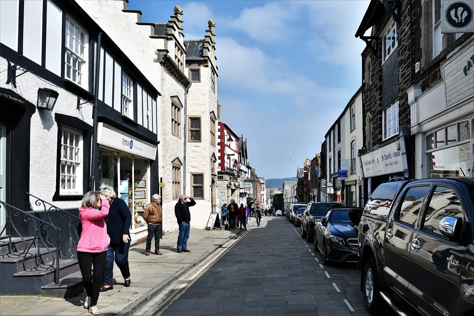 Conwy High Street, shopfronts and the town walls beyond
