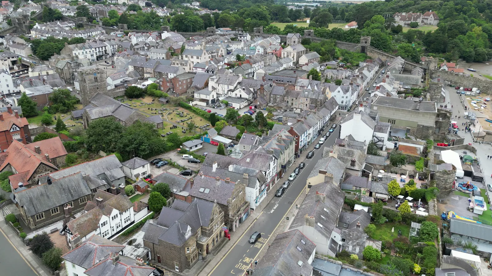 An elevated view of Conwy's High Street, St Mary's churchyard and the town walls, the town gathered inside its historic core