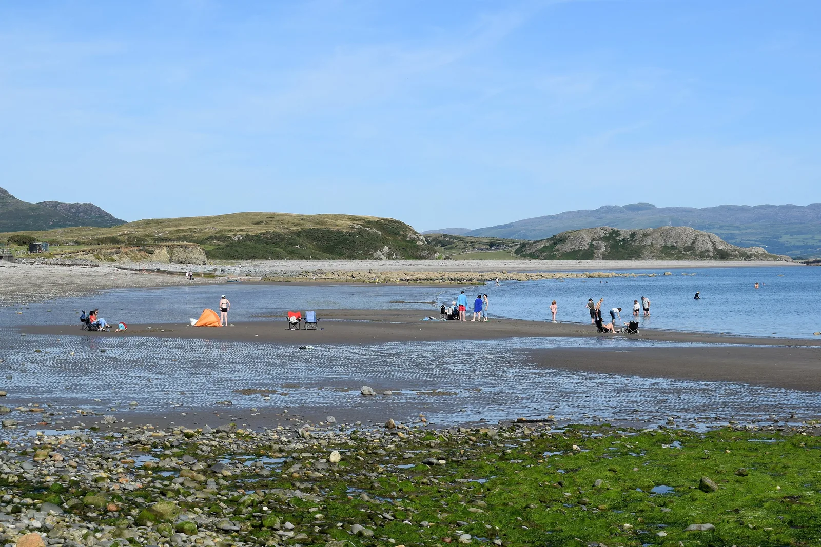 East Beach at Criccieth at low tide, wide wet sand with the hills across the bay beyond