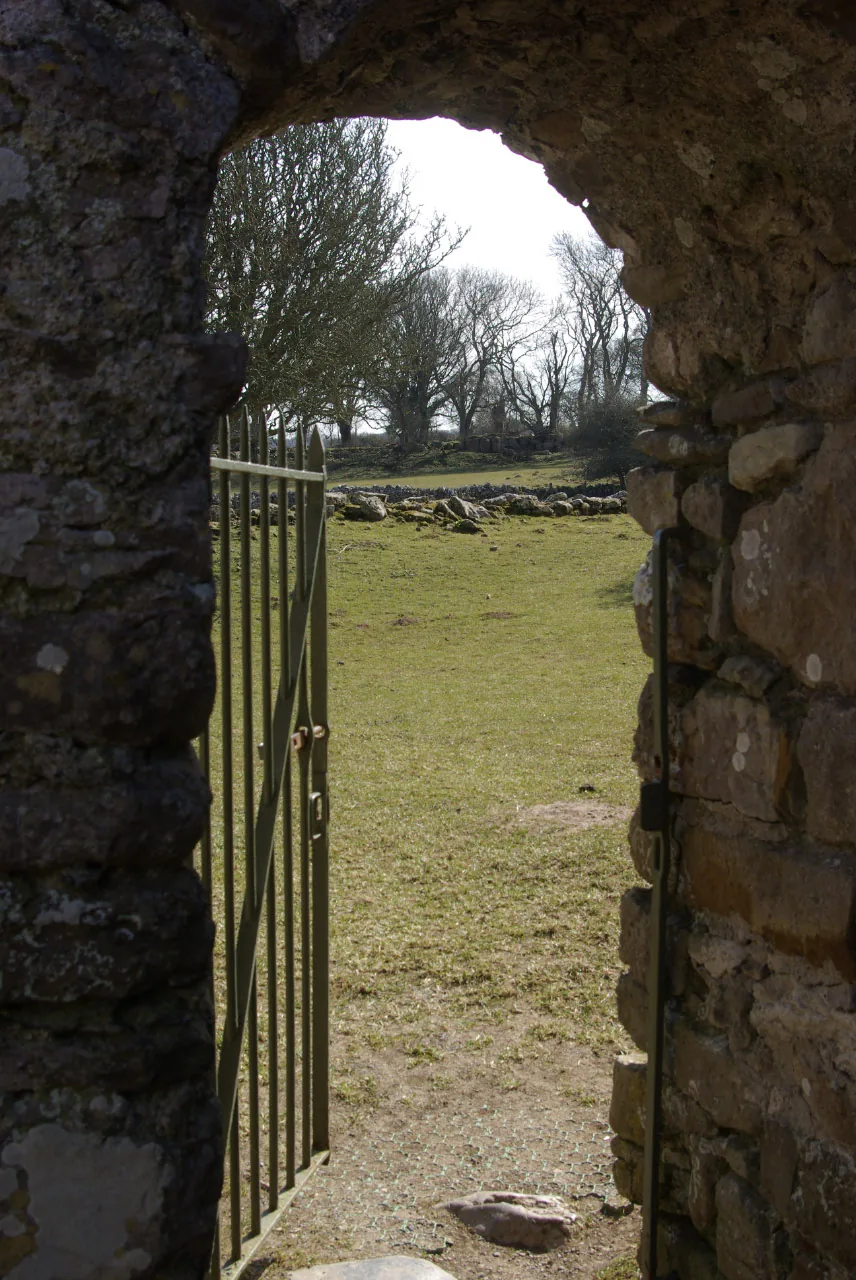 The view out through the arched stone doorway of Hen Capel Lligwy to the surrounding fields and trees.