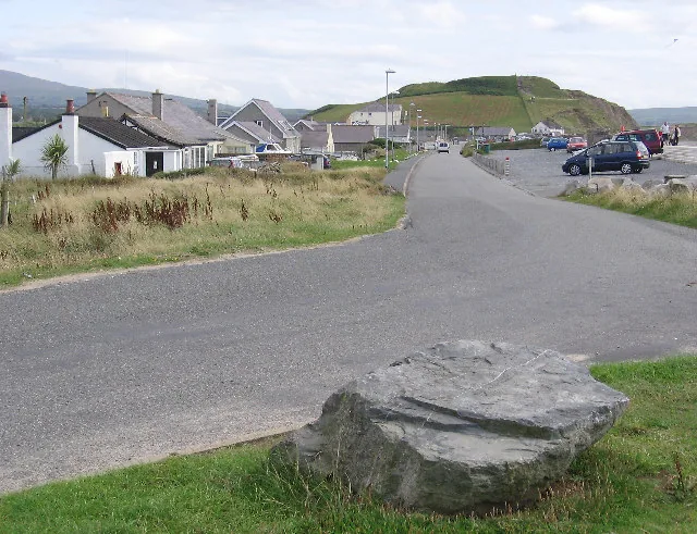 The road down to Dinas Dinlle with the Iron Age hillfort mound rising behind the seafront houses.
