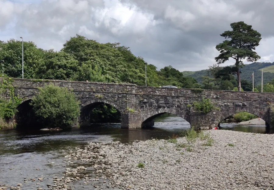 Y Bont Fawr, the stone bridge into Dolgellau, with the town and the hills of southern Eryri behind.