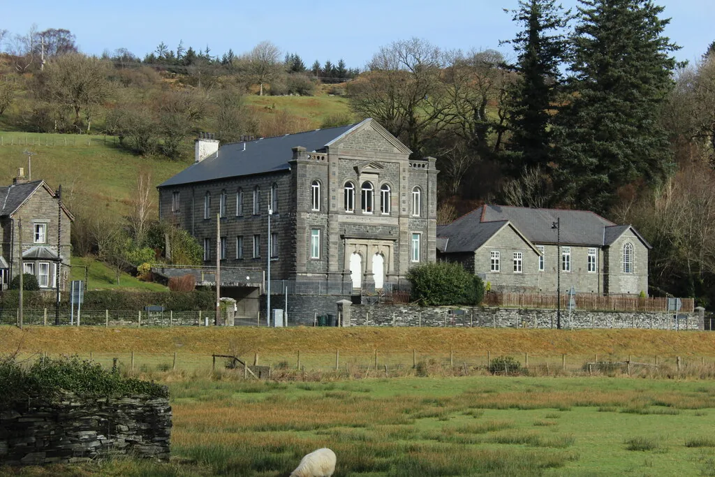 Capel Moreia at Dolwyddelan seen across the floodplain, a tall chapel gable among trees