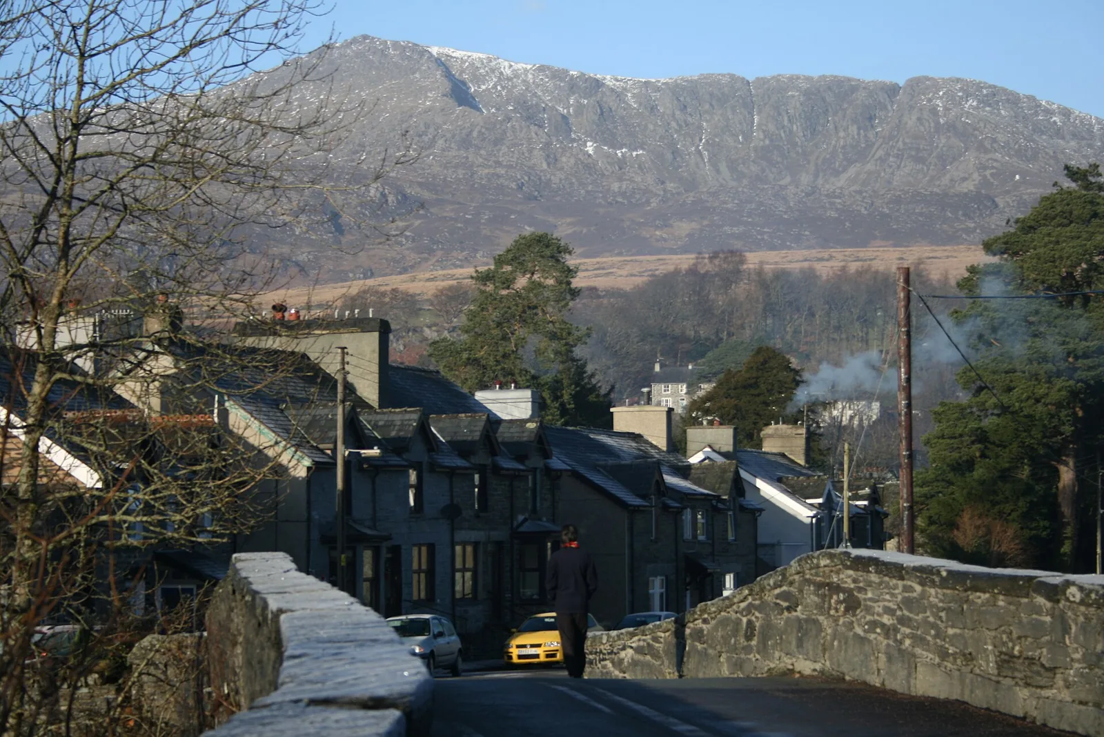 Dolwyddelan seen from the parapet of Pont-y-Llan, slate terraces climbing away with snow on the ridge of Moel Siabod behind