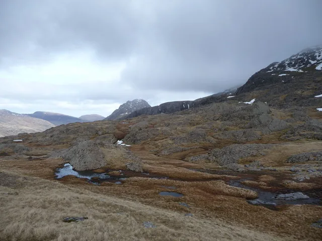 Rocky outcrops and marshy, wintry ground near Llyn y Cwn, on the descent from Glyder Fawr