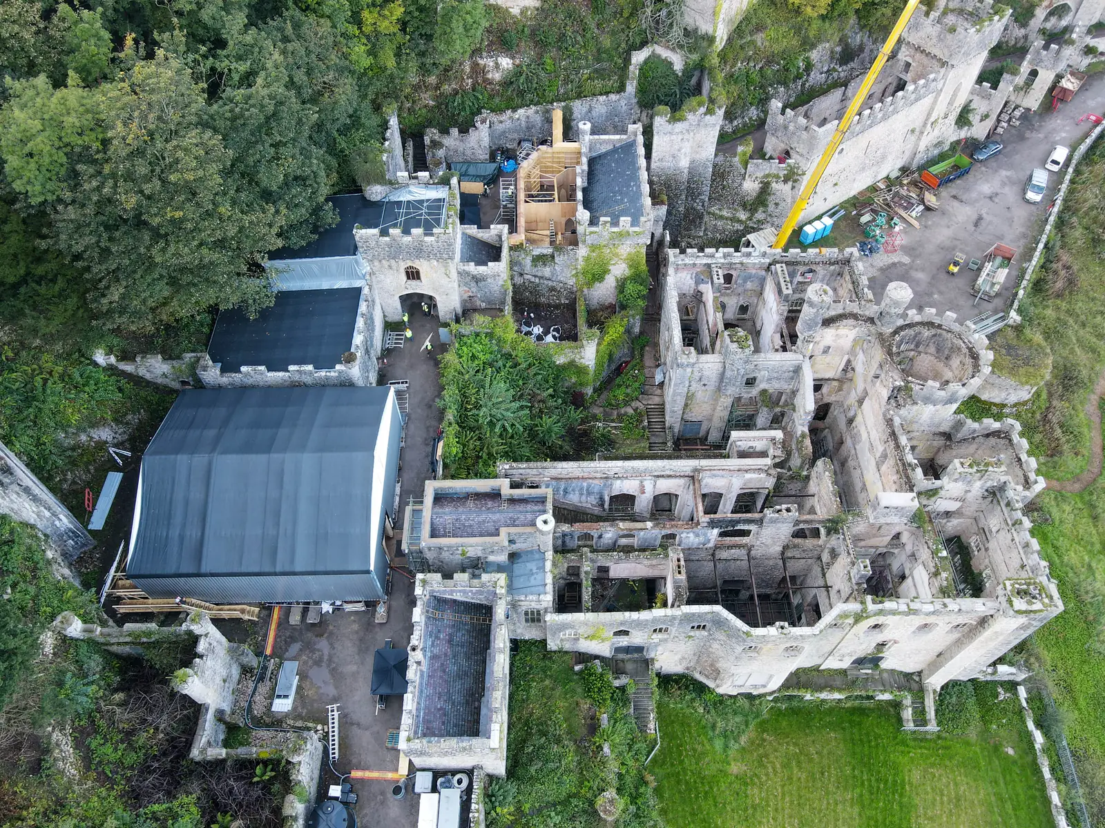 An aerial view of Gwrych Castle during the 2020 production build for I'm A Celebrity... Get Me Out of Here!, with marquees and roofing tarps over the ruin.