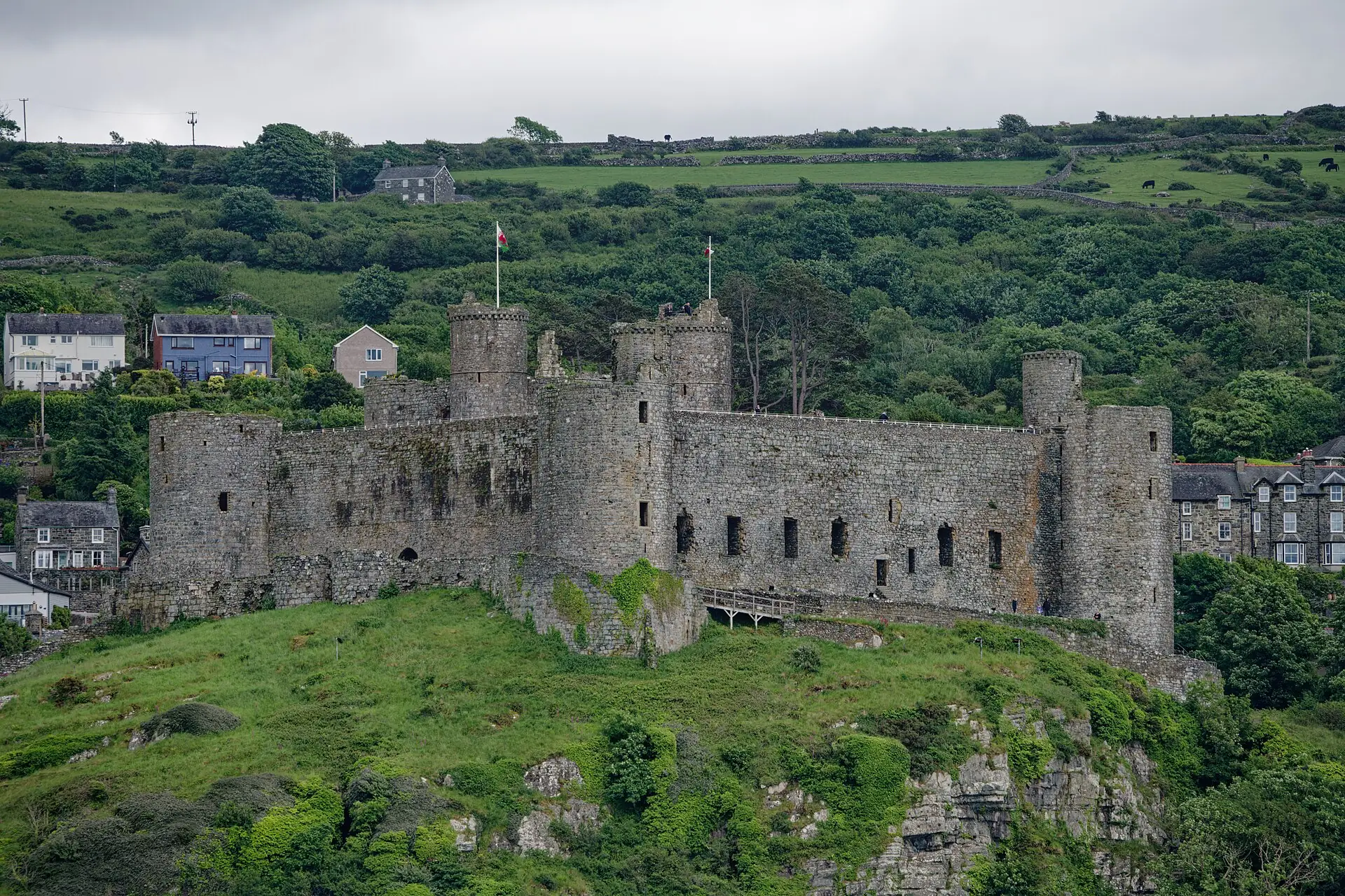 Harlech Castle on its crag above the dunes, with the mountains of Eryri rising behind it under a wide Gwynedd sky.
