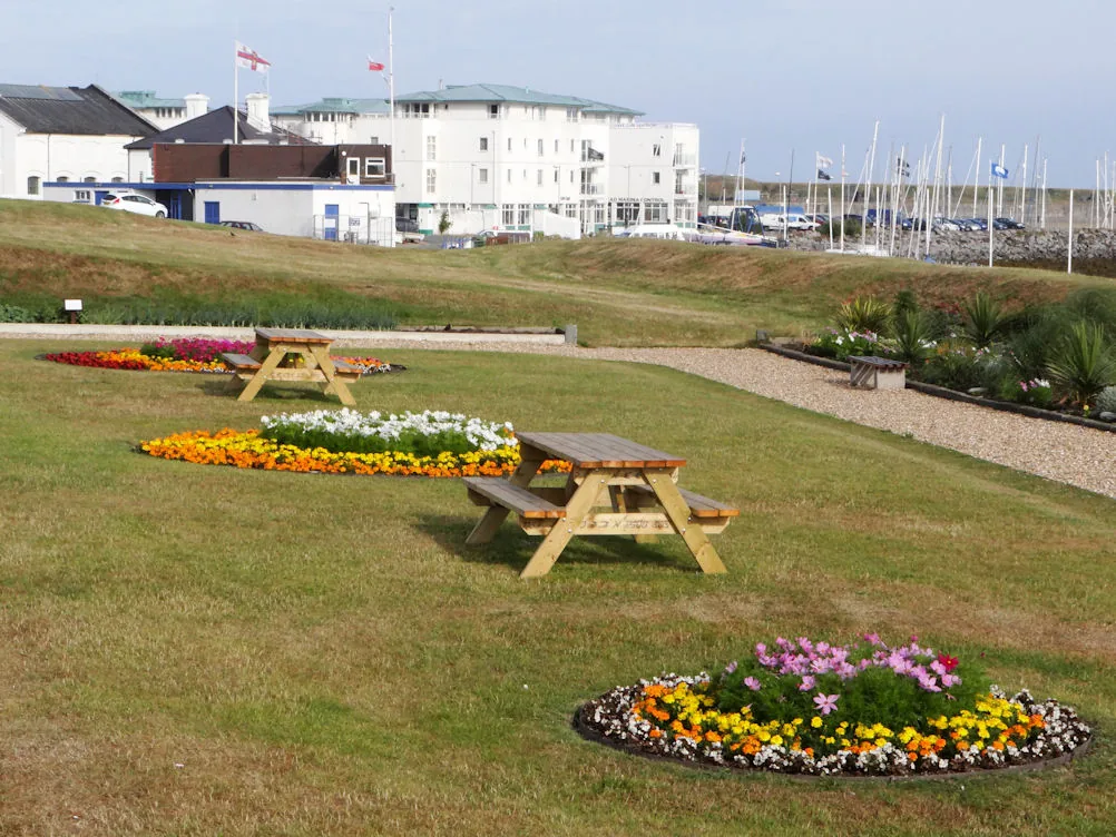 Newry Beach at Holyhead, the grassy greens and sheltered waterfront, the harbour and marina beyond