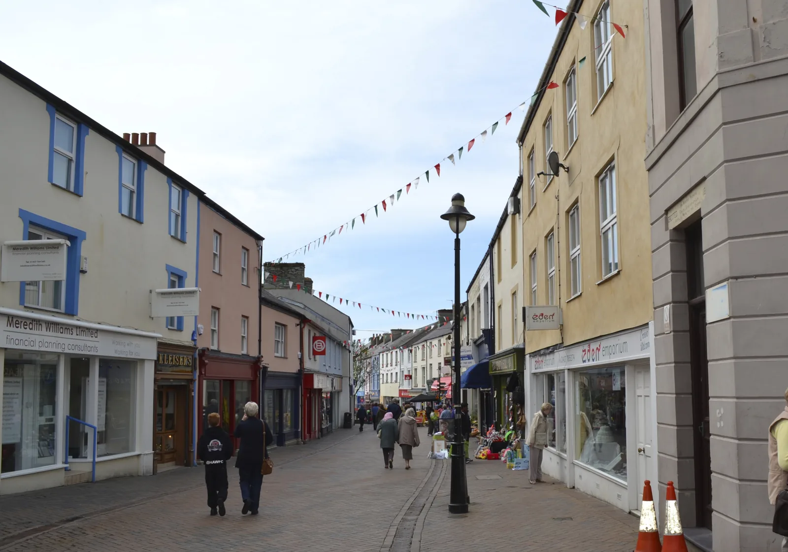 Shoppers and shopfronts along the pedestrianised Market Street in Holyhead, bunting overhead