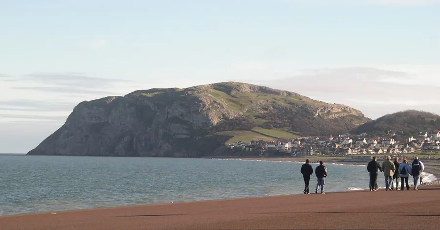 The Little Orme headland rising from the sea above the Llandudno shore, Conwy.
