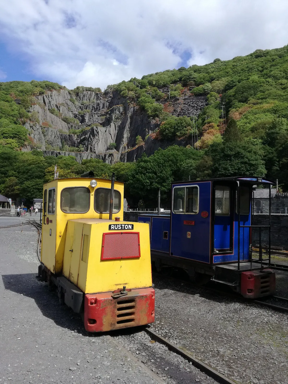 Narrow-gauge quarry locomotives in the museum yard at Gilfach Ddu, the Dinorwig quarry face behind