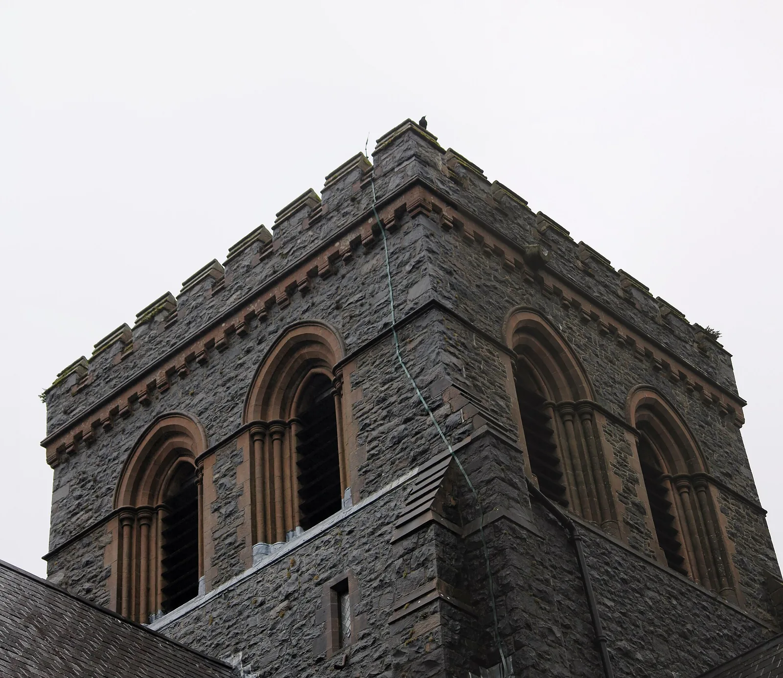 The crenellated tower of St Padarn's Church, Llanberis, seen close up against the sky