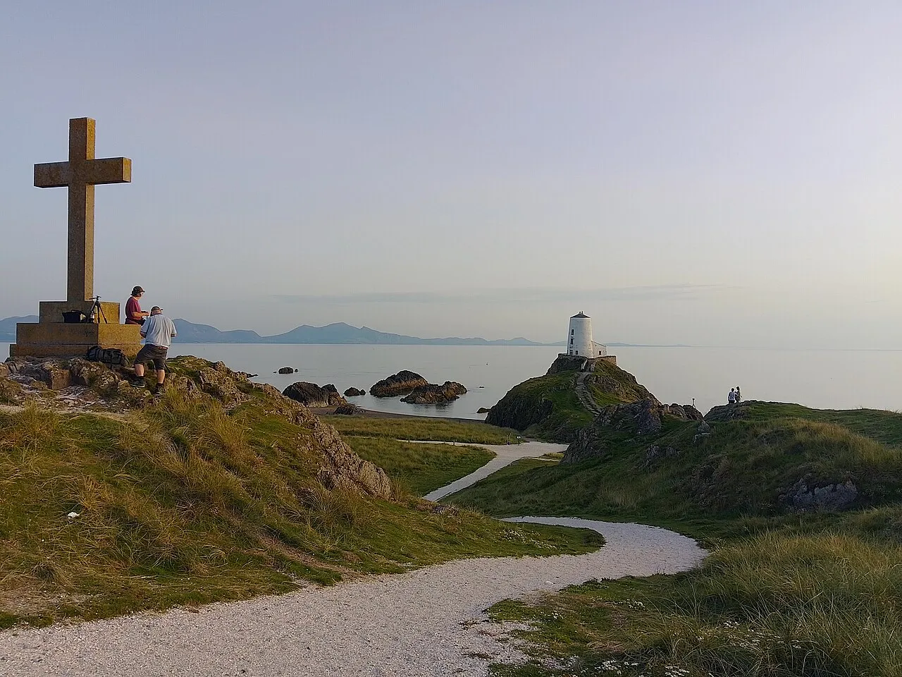 The Celtic cross and white lighthouse at the tip of Llanddwyn Island.