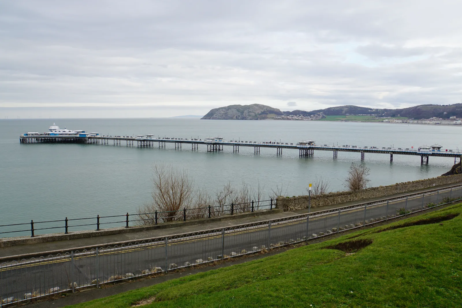 Llandudno Pier seen from Happy Valley, its full length reaching into the bay with the Little Orme beyond