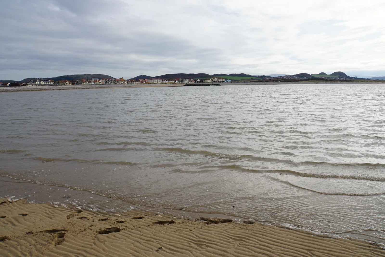 The wide flat estuary shoreline at West Shore, Llandudno, low land visible across the water