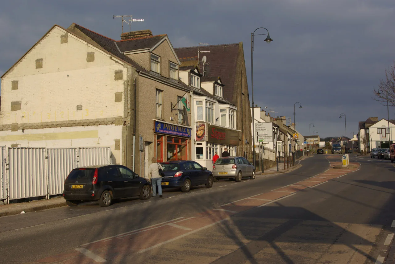 Bridge Street, Llangefni, in low evening light: a terrace of shops and houses along a wide road out of the centre
