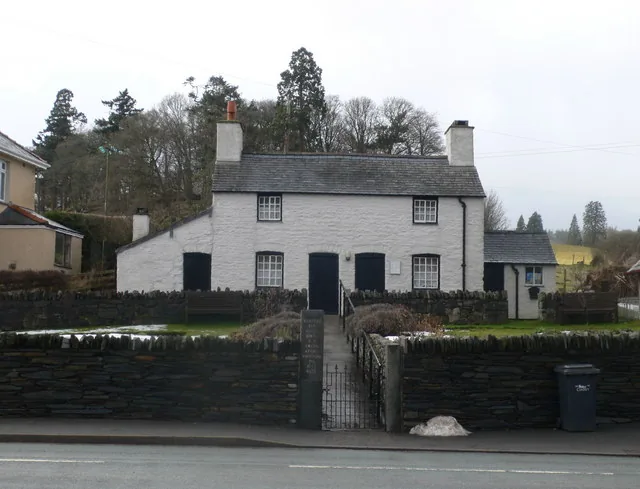 Y Cwm, a pair of whitewashed labourers' cottages set behind a low wall on the A548 at Llangernyw