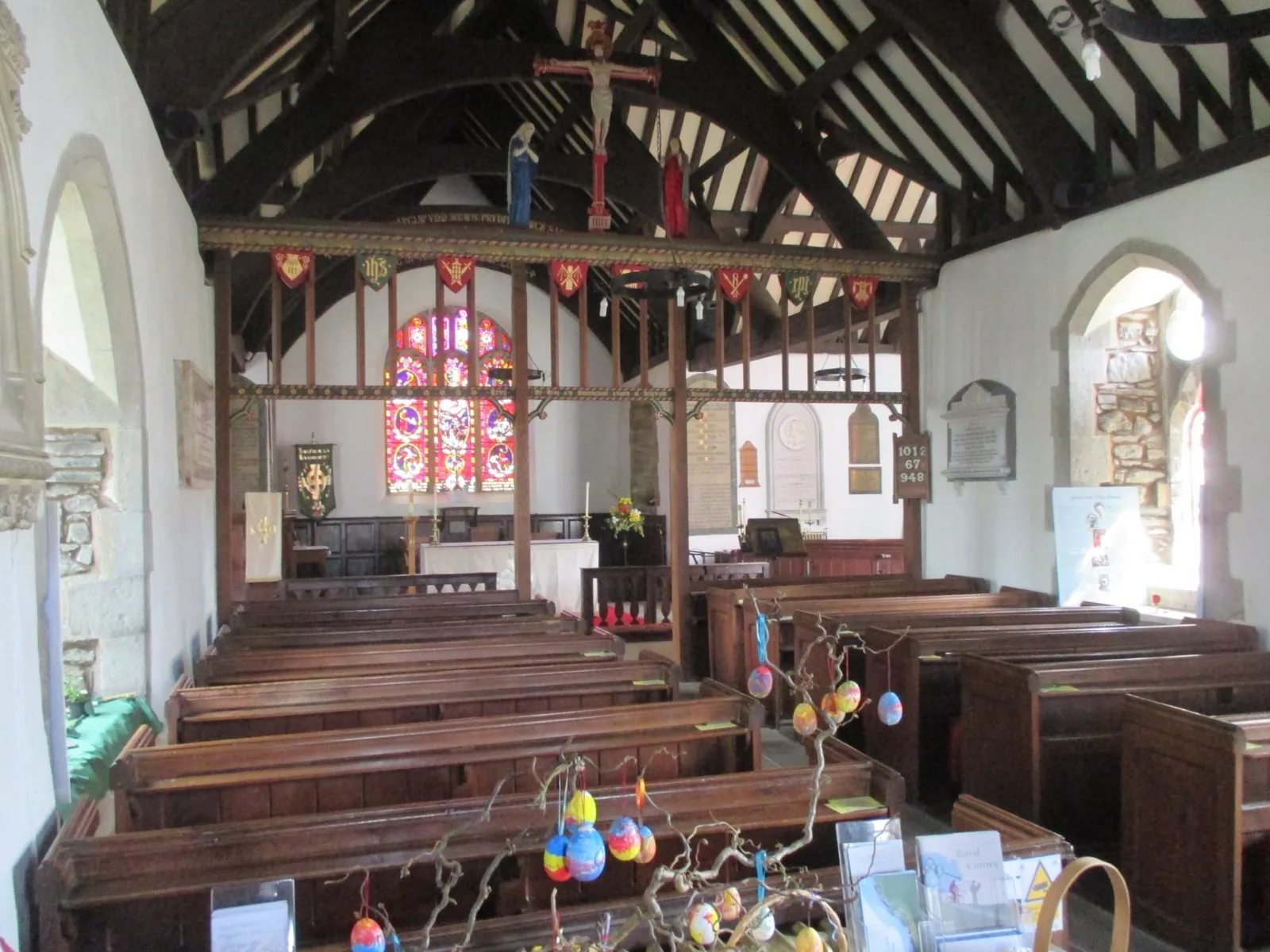 Inside St Digain's Church, Llangernyw: dark roof timbers over whitewashed walls and box-ended pews