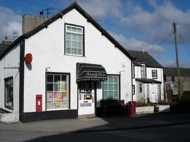 The village shop at Llangernyw, a whitewashed frontage with an awning and a postbox set into the wall