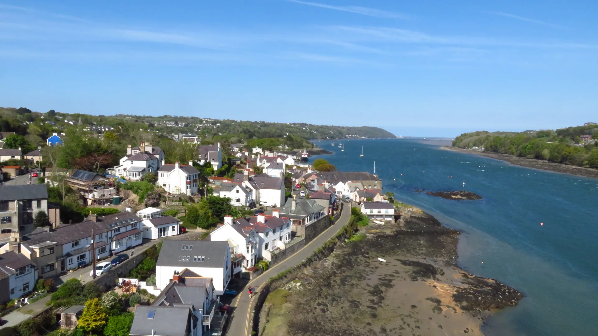 Menai Bridge from above: the town's houses stepping down to the turquoise water of the Menai Strait.