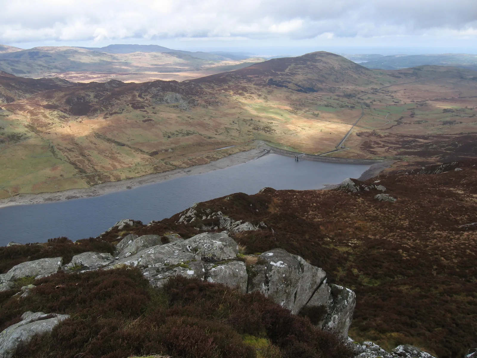 Looking down the full length of Llyn Cowlyd to its dam, with the Conwy valley and the coast beyond