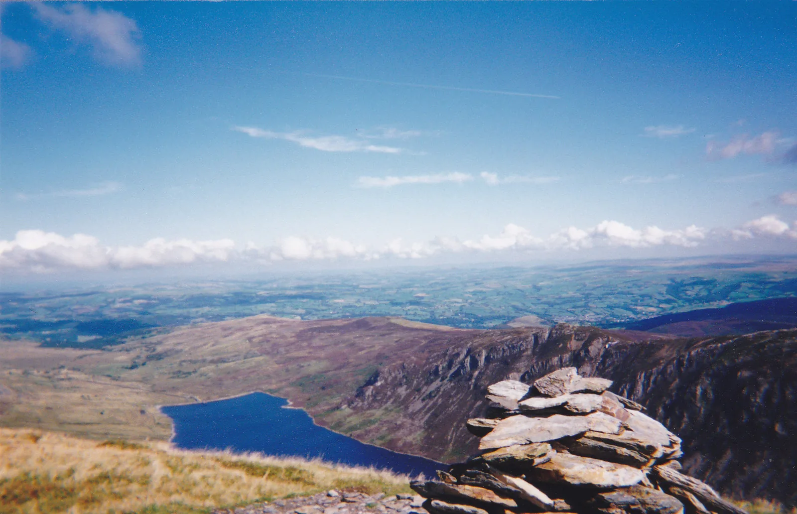 The summit cairn on Pen Llithrig y Wrach with Llyn Cowlyd below and the Conwy valley stretching to the sea