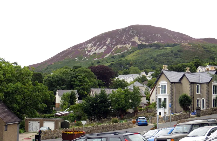 Penmaenmawr's slate roofs below the heathered flank of Foel Lus rising directly behind the town.