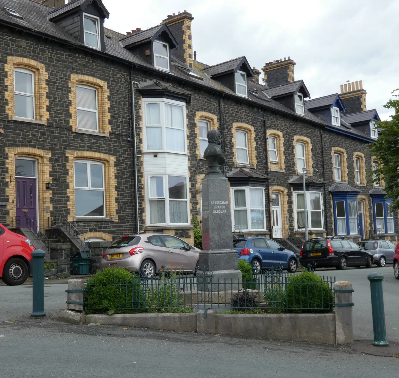 The Gladstone Memorial on its railed island in Penmaenmawr, a Victorian stone terrace rising behind it