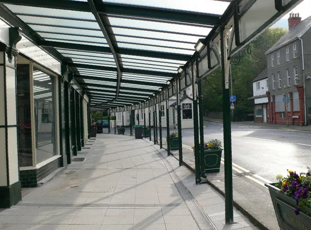 The glazed Victorian arcade canopy running along the pavement outside shops in Penmaenmawr