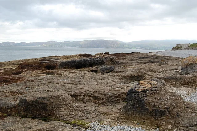 The rock-and-shingle shore at Penmon Point, looking out to sea.