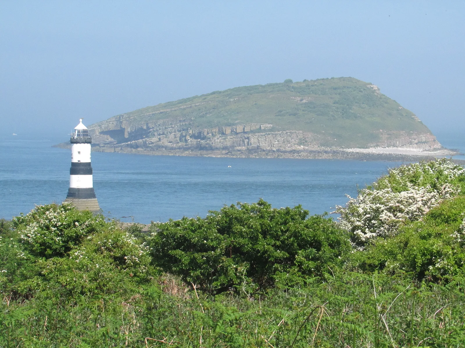 The Trwyn Du Lighthouse on its rock off Penmon Point, with Puffin Island lying low across the sound.
